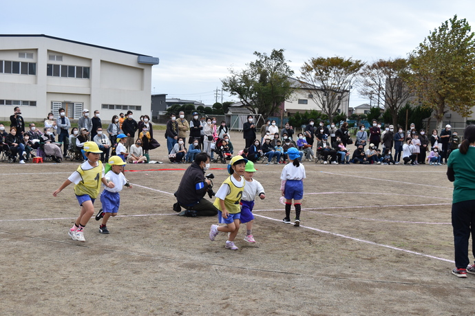 かけっこでゴールした年中児の手を引く年長児