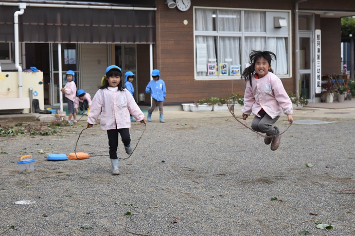 芋のツルで縄跳びをする園児