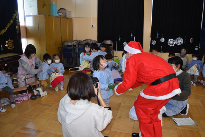 サンタクロースさんからプレゼントをもらう園児