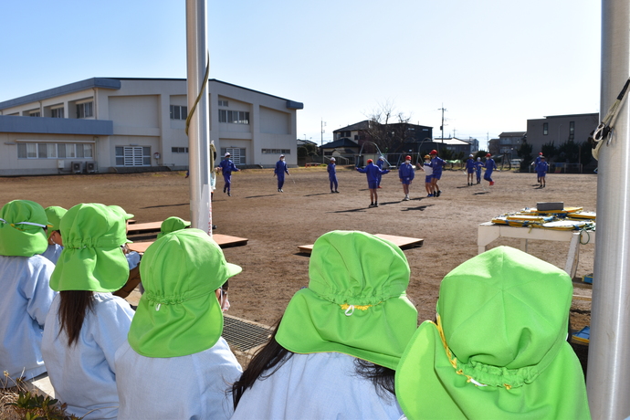 小学生の縄跳びを見る園児