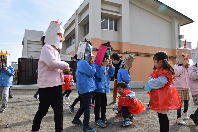 鬼のお面をかぶって年少児の前に立つ園児達