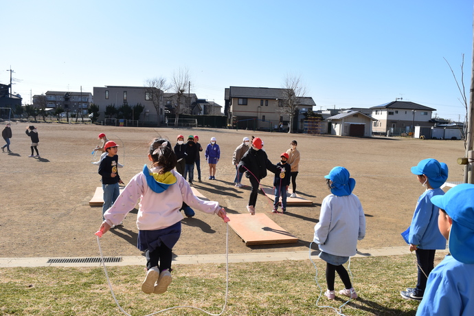 小学生の縄跳びを見る園児