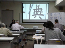写真：講師が文字の書き方を説明している様子