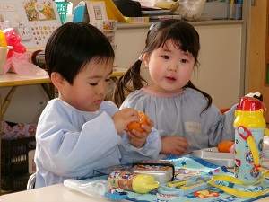 写真：もらったみかんを食べる年少