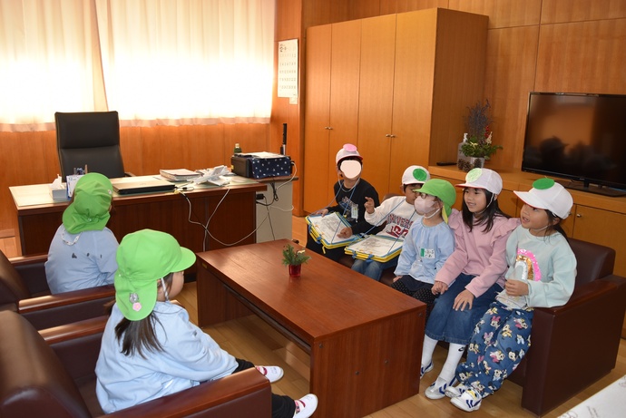校長室の応接セットに座る小学生と園児たち