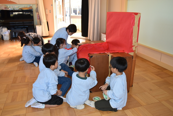 積み木を組んで椅子を作る園児たち