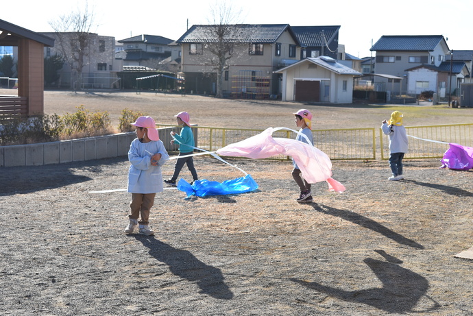 ポリ袋の凧を揚げる園児