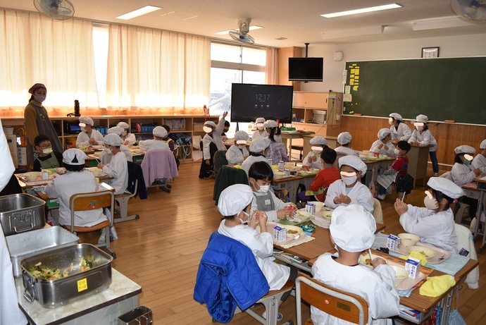 給食を食べる園児と小学生