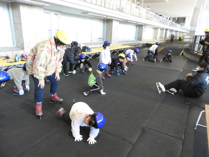 スケート靴を履いて準備運動をする園児たち