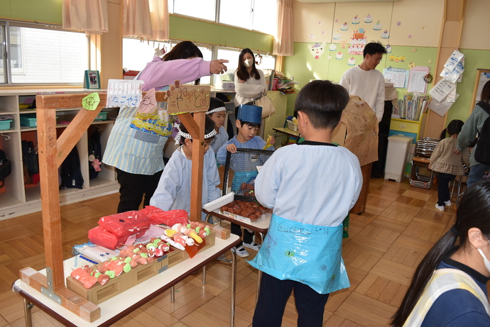 焼き鳥やたこ焼きの屋台で売る園児と客