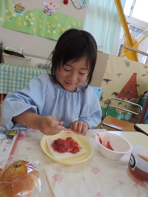 写真：いちごジャムサンドを食べる女児