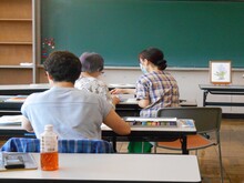 写真：講師が受講者に塗り方の指導をしている様子