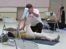 写真：講師が受講者にストレッチの指導をしている様子
