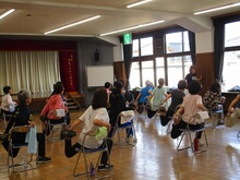 写真：椅子に座って足首を掴んでいる様子