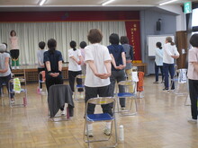 写真：手を後ろで組んで胸を開く運動をしている様子