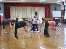写真：講師が受講生の肩甲骨をチェックしている様子