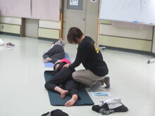 写真：講師が受講者をマッサージしている様子