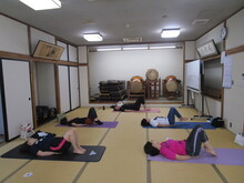 写真：尾てい骨の下に手を置いて足を曲げながら床につけないようにしている様子