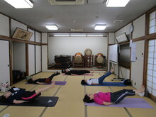 写真：尾てい骨の下に手を置いて足を伸ばしながら床につけないようにしている様子