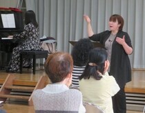 写真:顎に手を当てながら歌っている様子