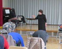 写真:前屈しながら発声練習している様子