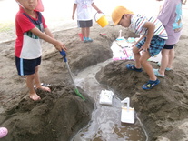 砂場で大きな川を作る園児たち