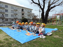 桜の木の下でおやつを食べる園児たち