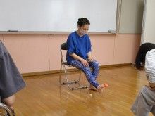 写真:講師がスーパーボールを足の指でつまみ持ち上げている様子